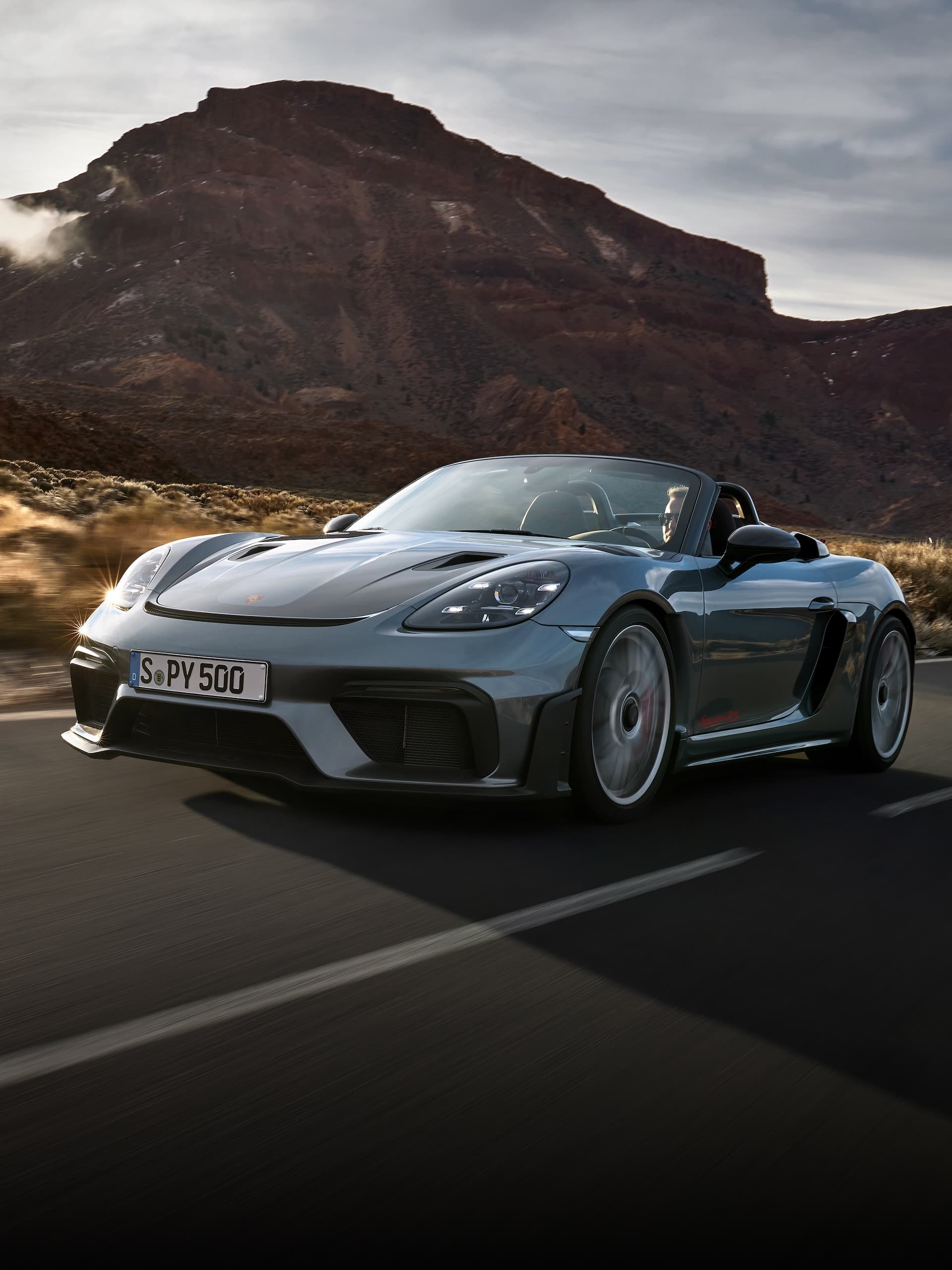 Porsche 718 Spyder RS conduisant sur la route entre les formations rocheuses.